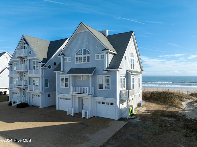 view of front of home with cooling unit, a water view, and a view of the beach