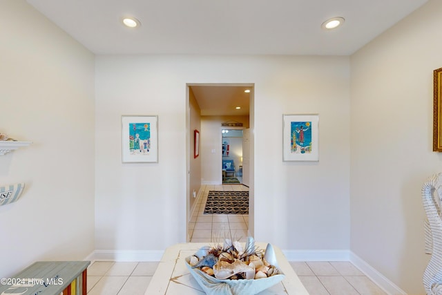 hallway featuring light tile patterned floors, baseboards, and recessed lighting