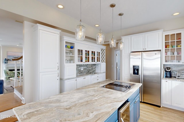 kitchen with black electric cooktop, beverage cooler, white cabinets, blue cabinetry, and stainless steel fridge