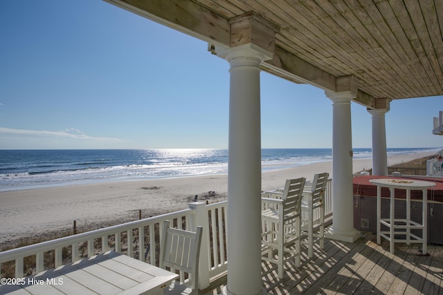 balcony with a water view and a view of the beach