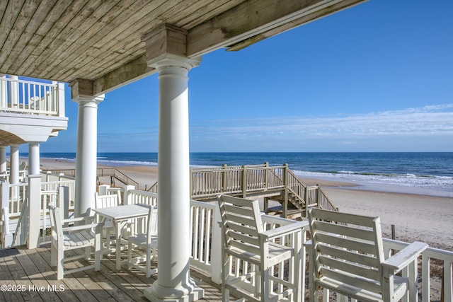 view of property's community featuring a water view and a beach view