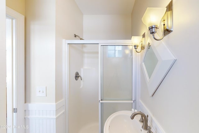 bathroom with a stall shower and a sink