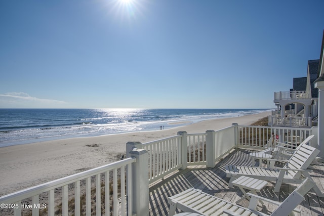 balcony featuring a water view and a view of the beach