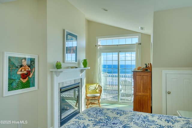 bedroom with access to exterior, lofted ceiling, visible vents, and a fireplace