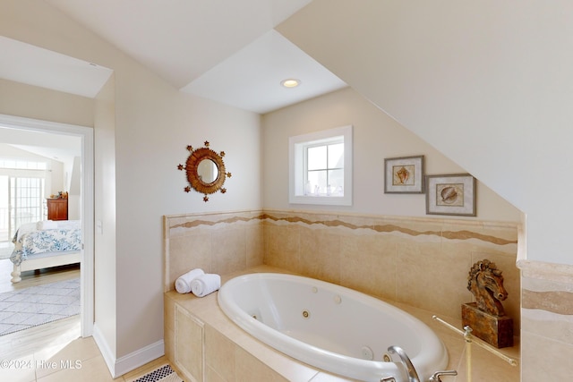 ensuite bathroom featuring baseboards, ensuite bath, a tub with jets, and tile patterned flooring