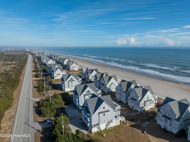 drone / aerial view with a residential view, a view of the beach, and a water view