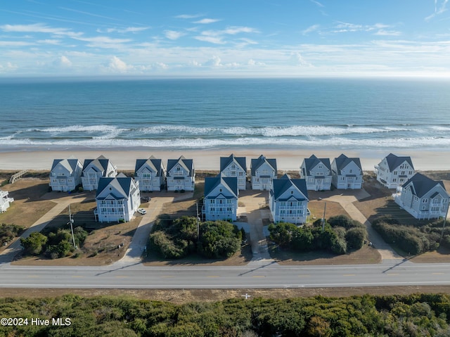 birds eye view of property featuring a water view, a residential view, and a beach view