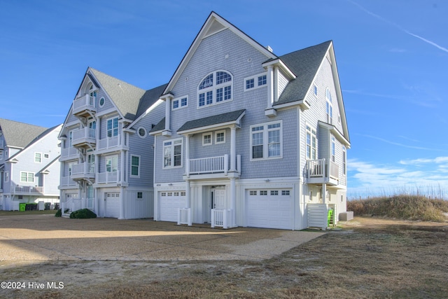 view of front of property with a shingled roof, cooling unit, driveway, and an attached garage