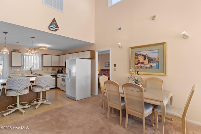 dining room featuring sink, a high ceiling, and a notable chandelier