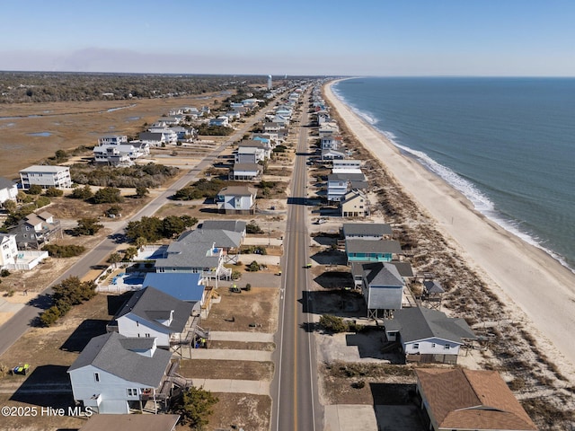 birds eye view of property with a water view and a beach view