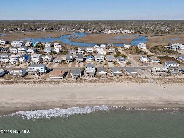 drone / aerial view featuring a water view and a beach view