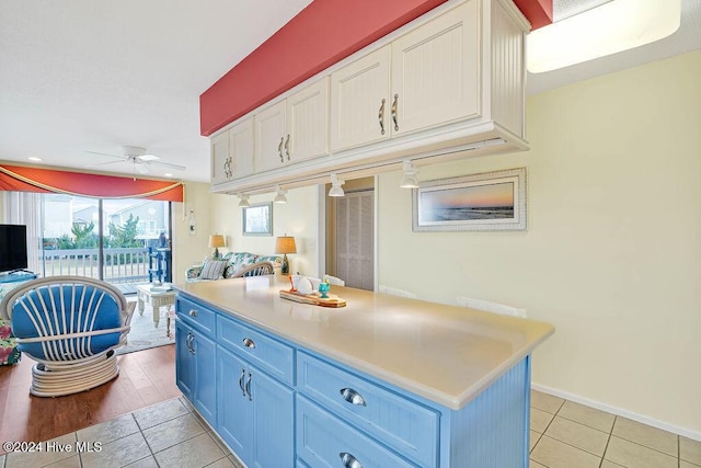 kitchen featuring blue cabinetry, ceiling fan, a center island, light hardwood / wood-style flooring, and white cabinets