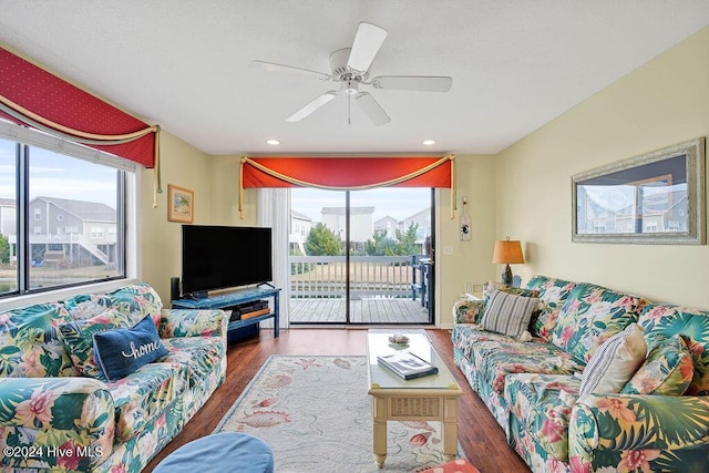 living room with dark hardwood / wood-style flooring and ceiling fan