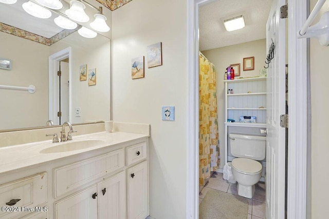 bathroom with toilet, vanity, and tile patterned floors