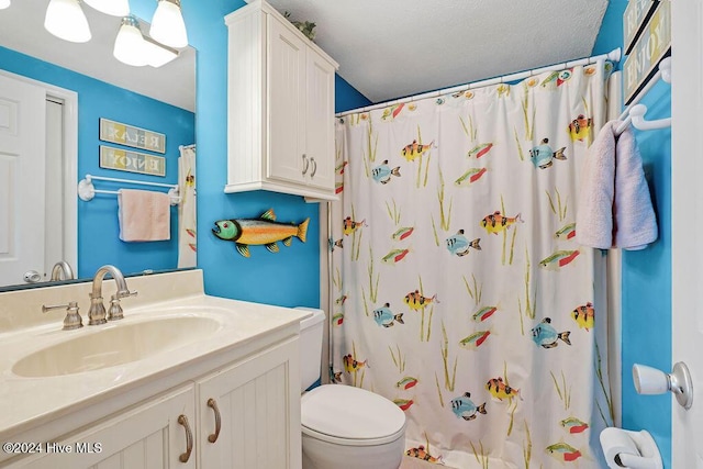 bathroom featuring a textured ceiling, vanity, toilet, and curtained shower