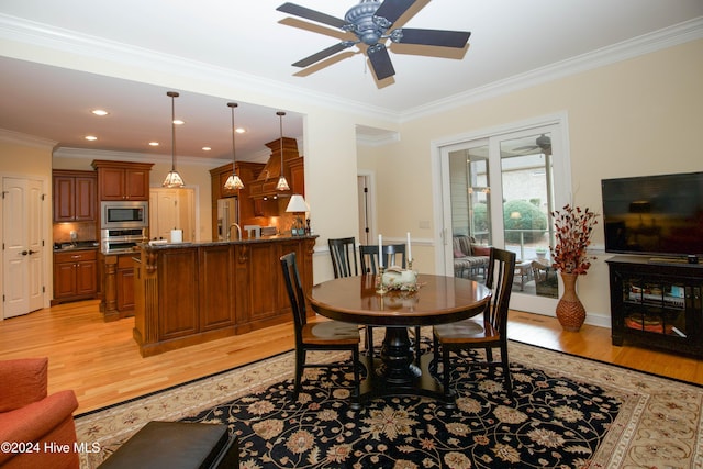 dining area featuring light hardwood / wood-style flooring, ceiling fan, and ornamental molding