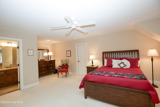 carpeted bedroom featuring ensuite bathroom, ceiling fan, sink, and vaulted ceiling