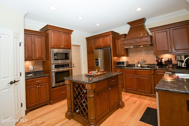 kitchen featuring tasteful backsplash, light hardwood / wood-style flooring, a kitchen island, and stainless steel appliances