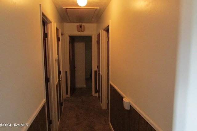 hallway featuring dark colored carpet