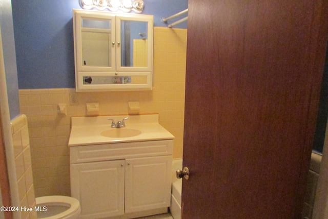 full bathroom featuring vanity, bathtub / shower combination, tile walls, and toilet