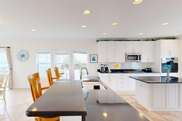 kitchen with sink, stainless steel appliances, and a kitchen island with sink