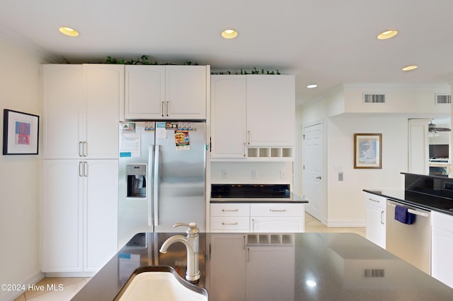 kitchen with crown molding, white cabinetry, stainless steel appliances, and light tile patterned floors