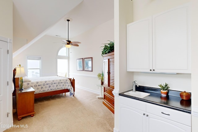 carpeted bedroom featuring high vaulted ceiling, ceiling fan, and sink