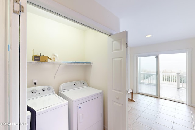 clothes washing area featuring washing machine and clothes dryer and light tile patterned floors