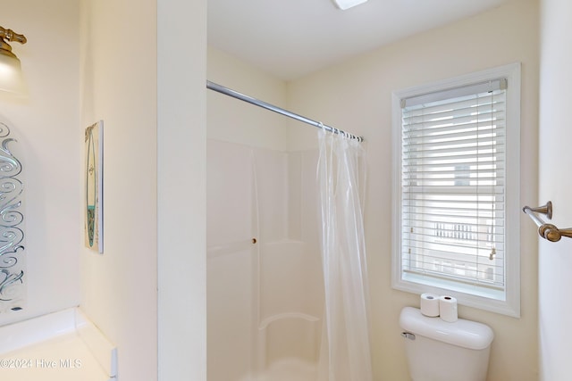 bathroom with curtained shower and toilet