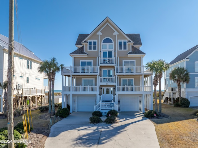 coastal home featuring a garage, a balcony, and french doors