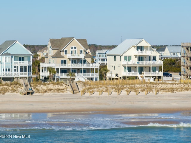 exterior space featuring a water view and a beach view