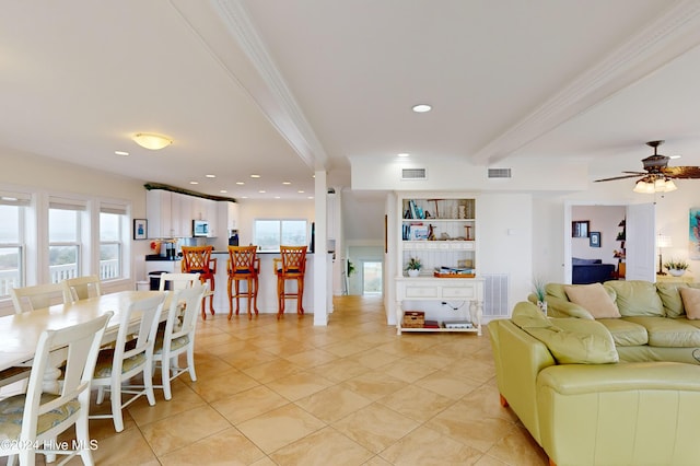 tiled living room featuring ceiling fan and ornamental molding