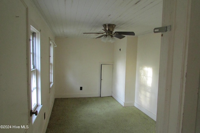 carpeted empty room featuring ceiling fan and wooden ceiling