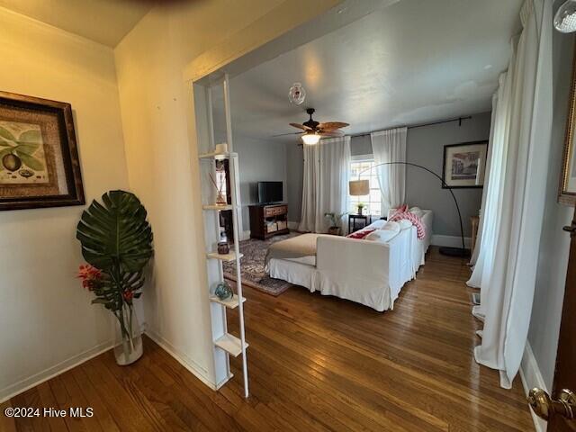 bedroom featuring ceiling fan, baseboards, and wood finished floors