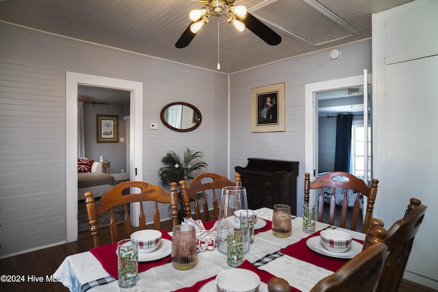 dining space featuring attic access, wood finished floors, and a ceiling fan