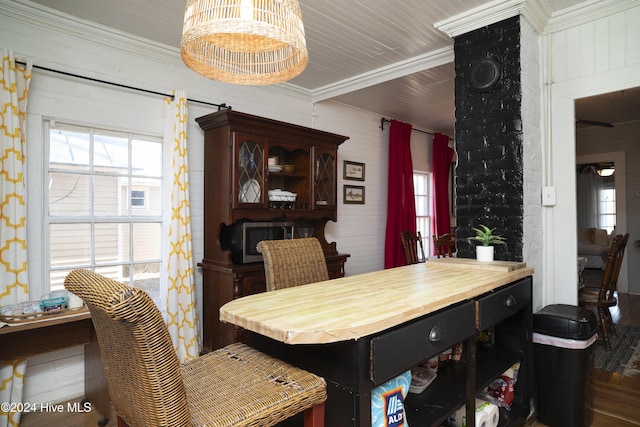 dining space with crown molding, a notable chandelier, wood finished floors, and a wealth of natural light