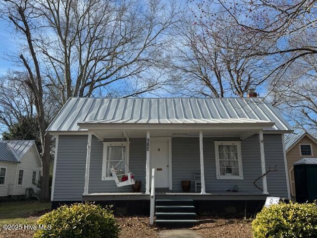 bungalow-style house with a standing seam roof, a porch, and metal roof