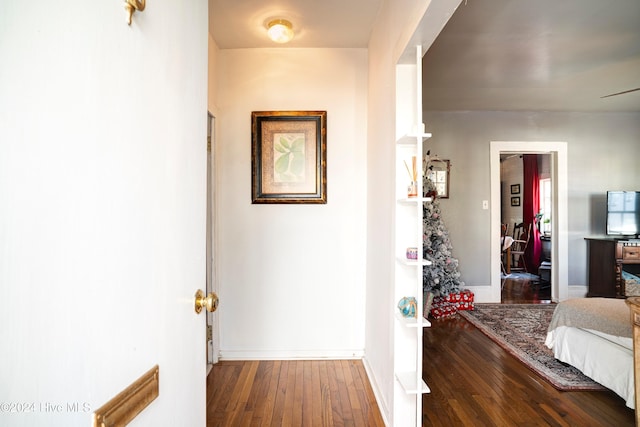 hallway with baseboards and hardwood / wood-style floors