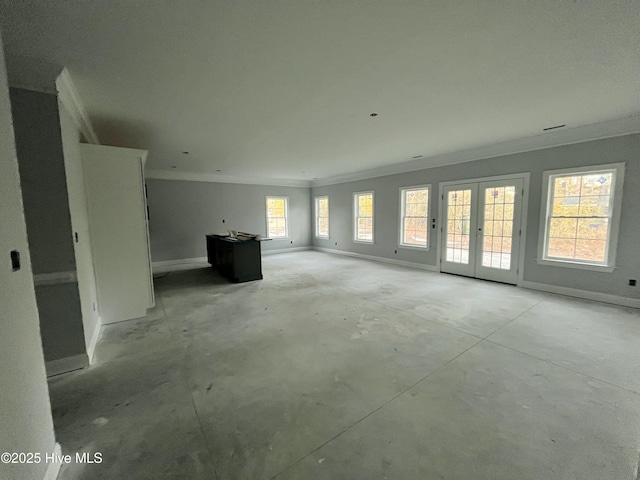 unfurnished living room with ornamental molding, unfinished concrete flooring, and baseboards