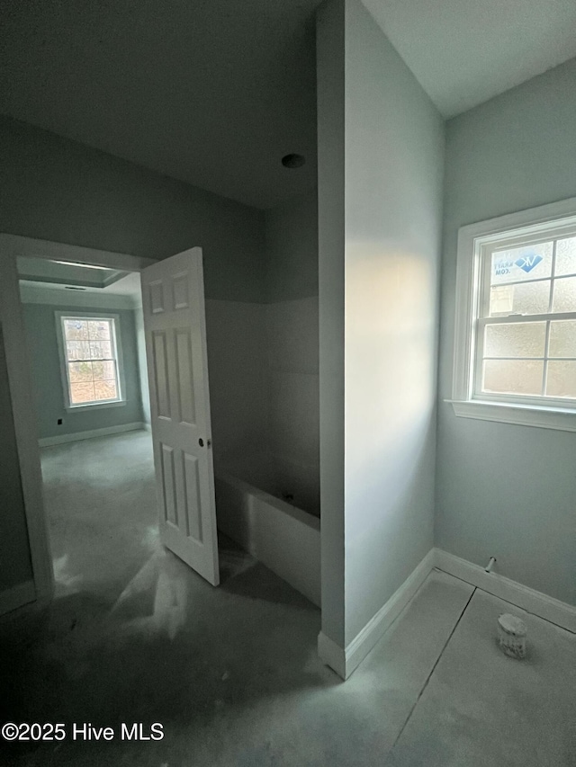 bathroom featuring a tub and baseboards