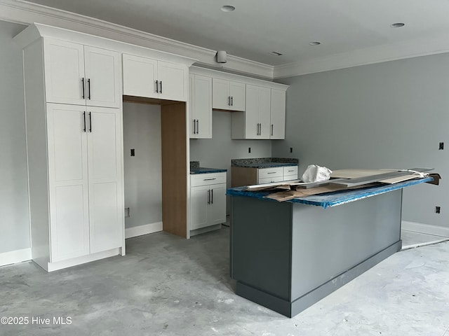 kitchen featuring crown molding, concrete floors, a kitchen island, and white cabinets