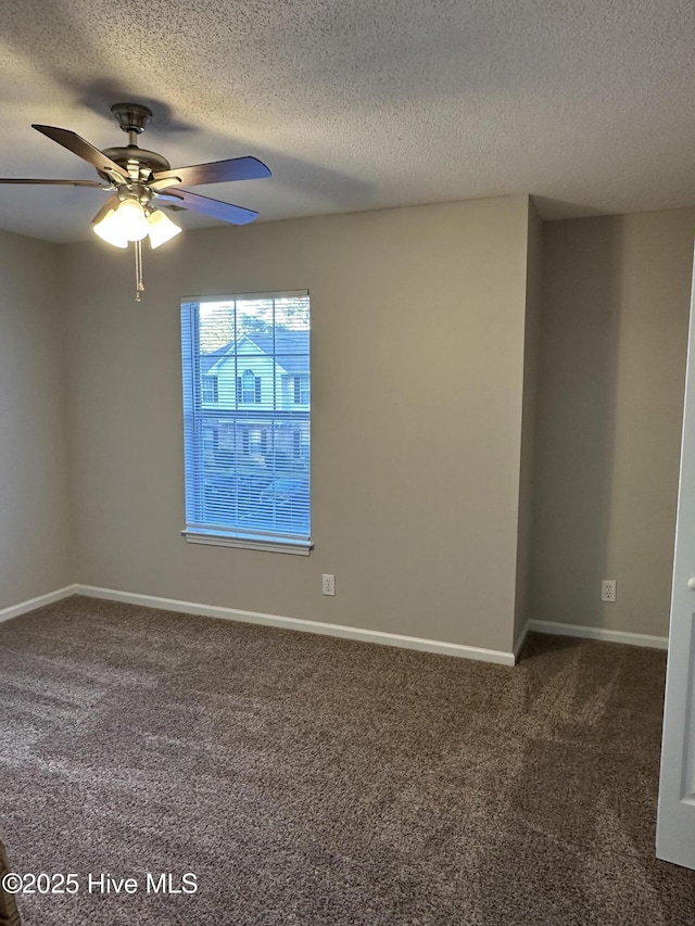 spare room with ceiling fan, a textured ceiling, and dark colored carpet