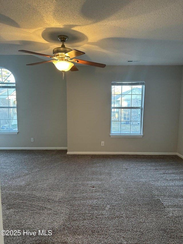 spare room with a textured ceiling, carpet floors, and ceiling fan