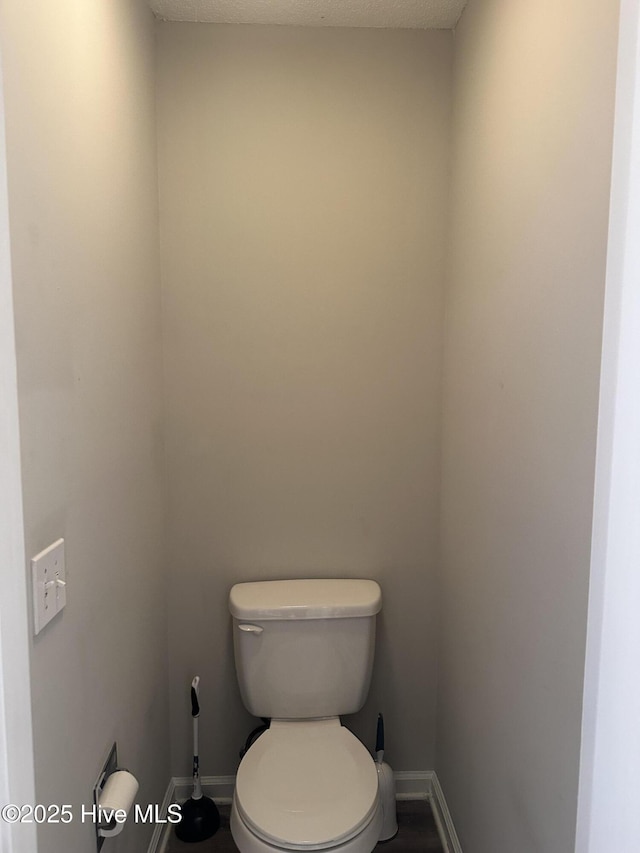 bathroom with a textured ceiling and toilet