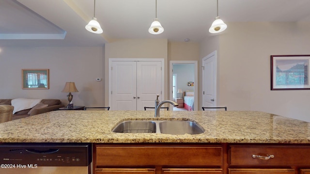 kitchen featuring dishwasher, decorative light fixtures, light stone counters, and sink