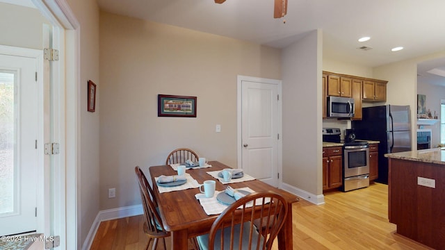 dining room with ceiling fan and light wood-type flooring