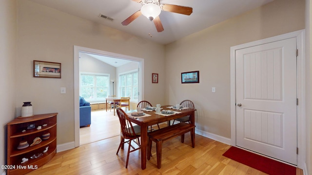 dining room with ceiling fan, lofted ceiling, and light hardwood / wood-style flooring