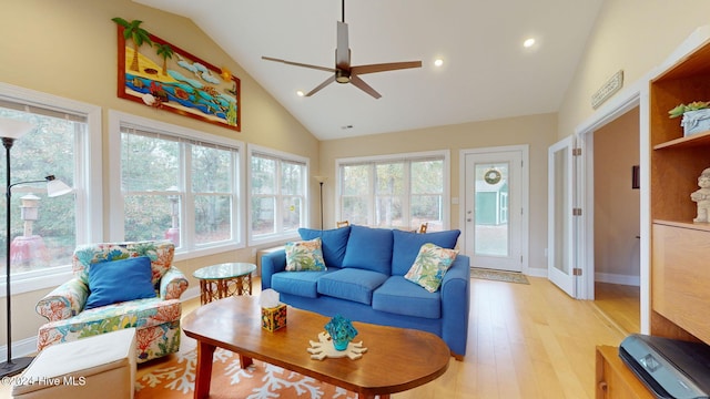 living room with light hardwood / wood-style floors, high vaulted ceiling, ceiling fan, and a healthy amount of sunlight