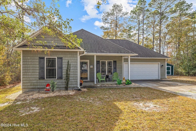 view of front of home with a front lawn, covered porch, and a garage