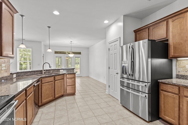 kitchen with hanging light fixtures, a wealth of natural light, sink, and stainless steel appliances